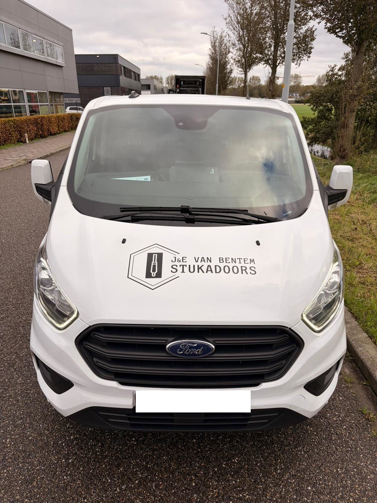 Voorkant van werkbeurs met bestickering erop van J en E stukadoors.