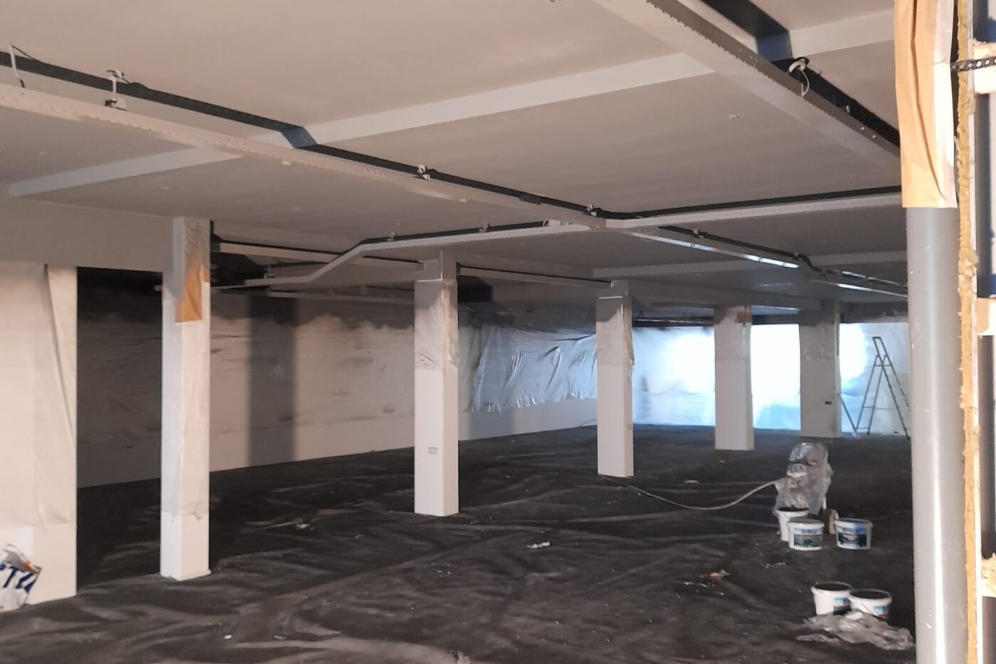 Stukadoor Hillegom uit de Bollenstreek 3 Industrieel plafond in een bedrijfsruimte tijdens professioneel spuitwerk